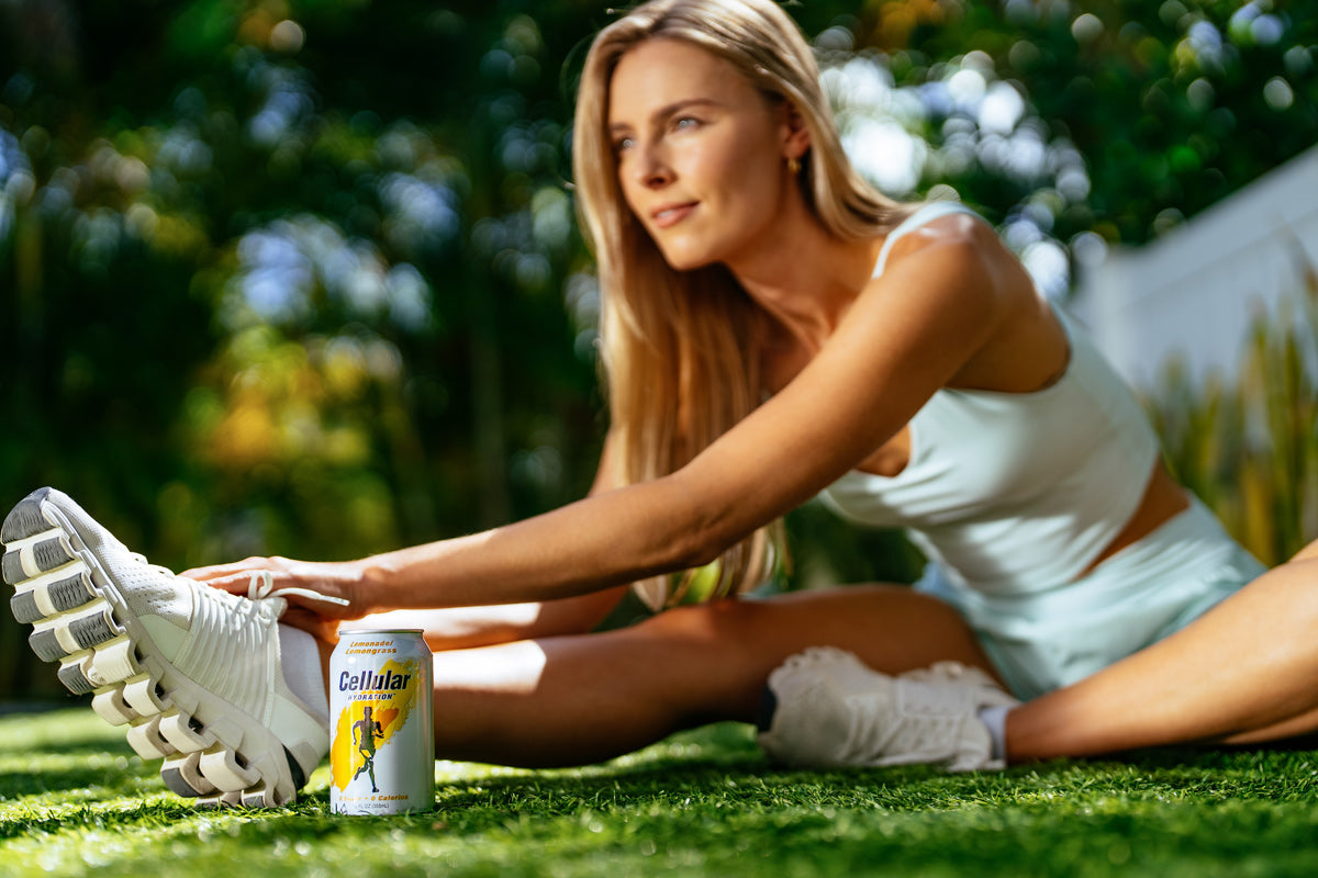 Can of sweetened Cellular Hydration in the foreground with an athletic woman stretching in the background