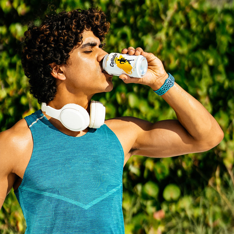 Man drinking Lemonade / Lemongrass flavor Cellular Hydration can wearing headphones
