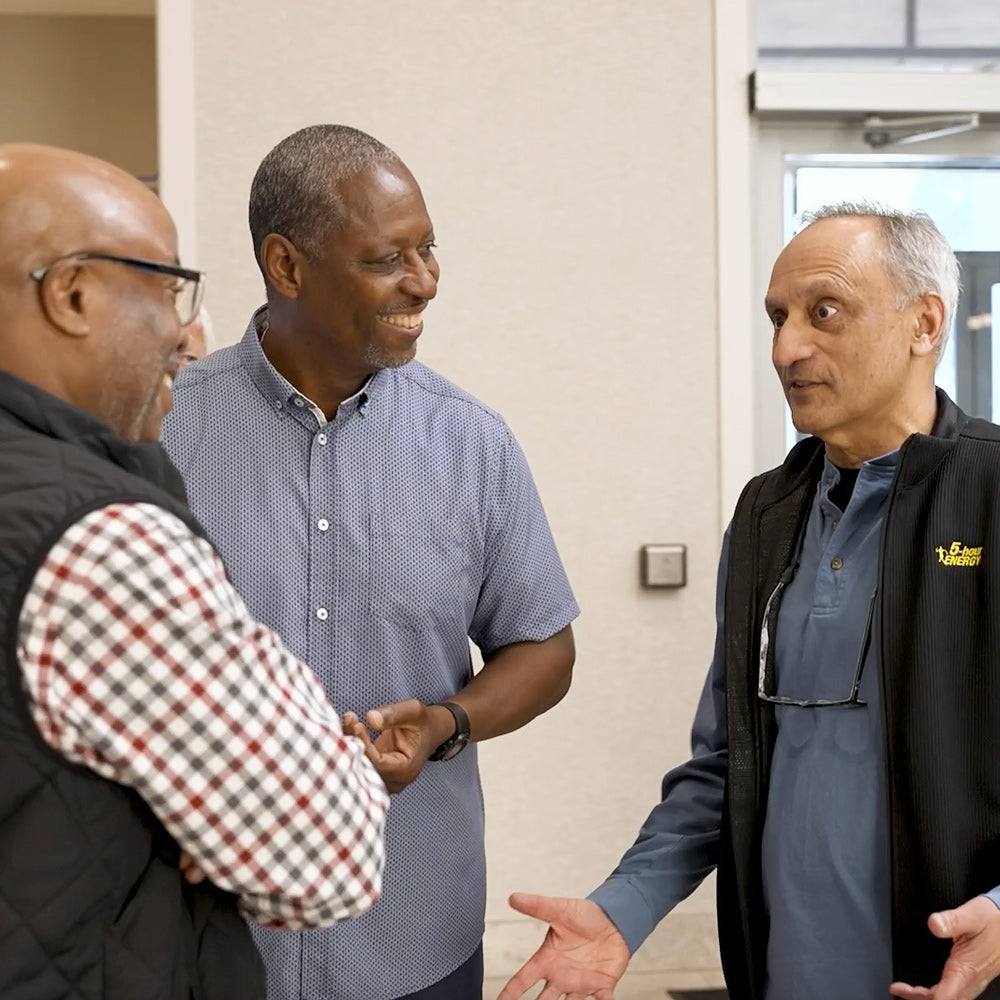 Manoj Bhargava, founder of 5-hour ENERGY, meeting with two attendees at a Truly Essential Event