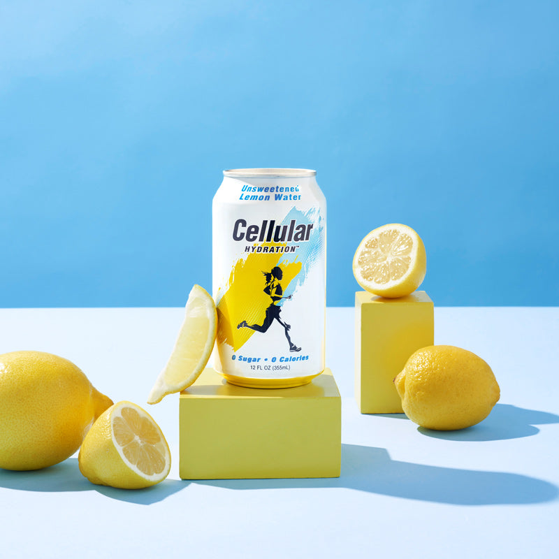 Unsweetened Lemon Water flavor Cellular Hydration can on yellow pedestal with lemons on blue background