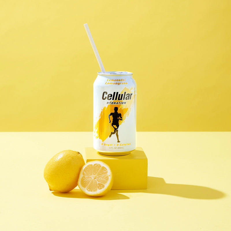 Lemonade / Lemongrass flavor Cellular Hydration can on yellow pedestal with lemons on yellow background