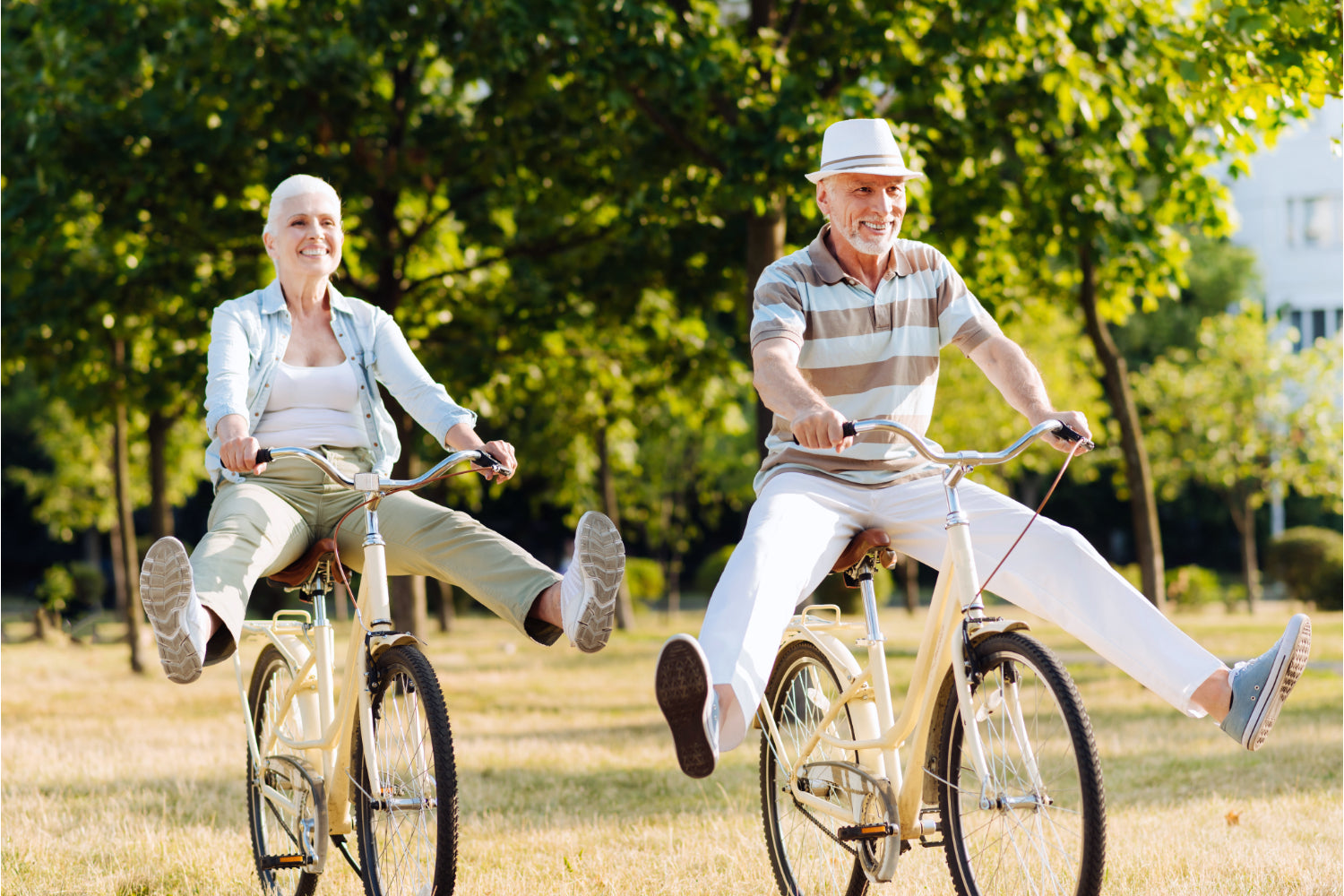 Old couple riding bikes with their feet sticking out like little kids