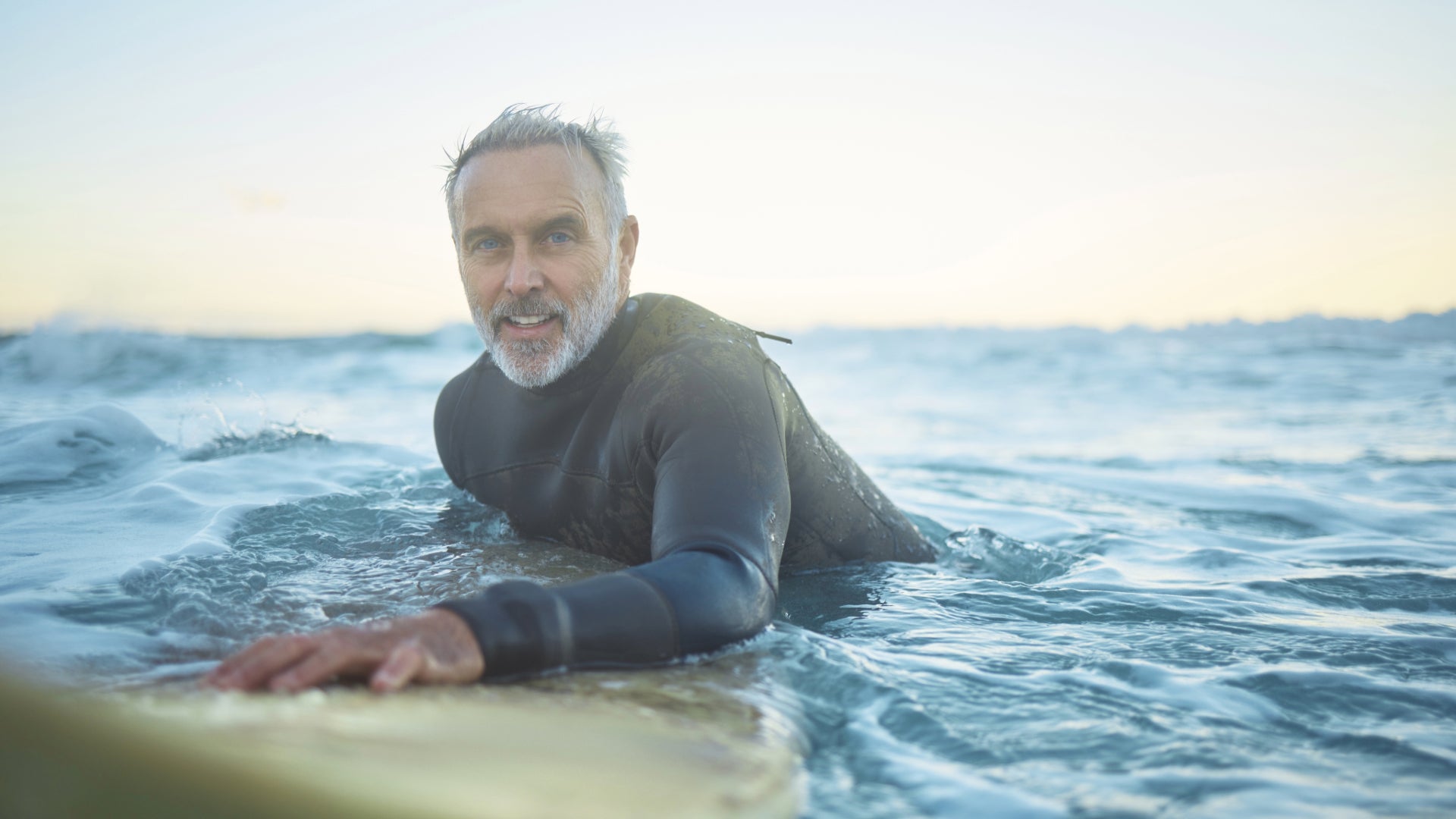 Old man surfing in the ocean